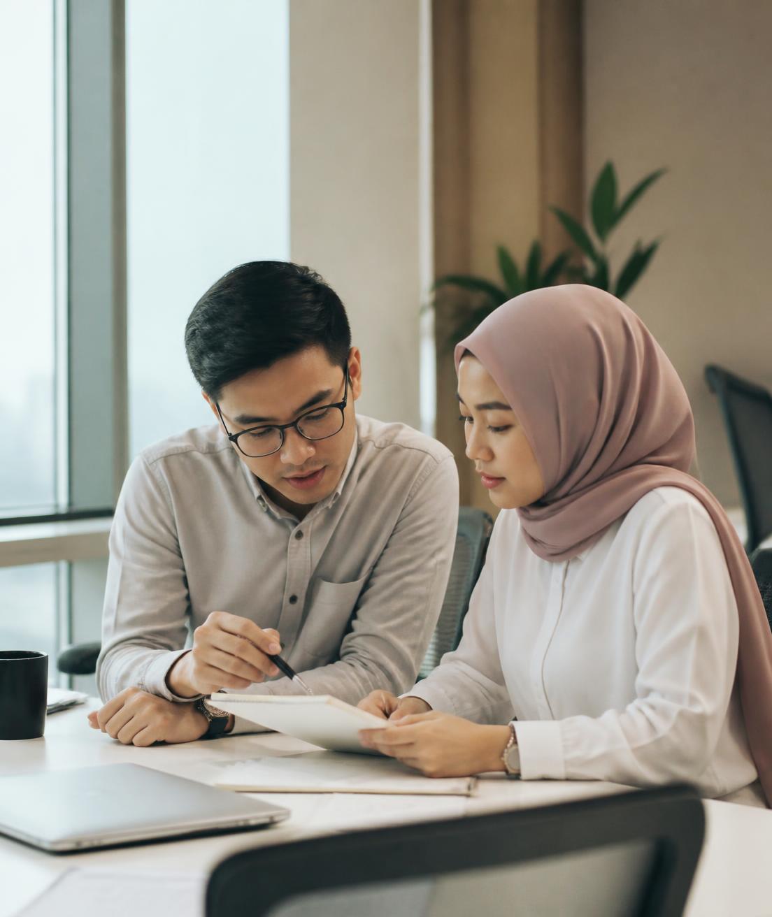 Two professionals reviewing planning notes together in a calm office